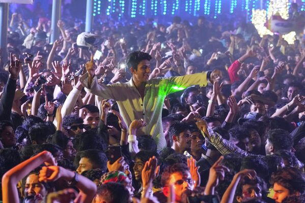 Местные жители и туристы празднуют Новый год на набережной в Мумбаи, Индия.