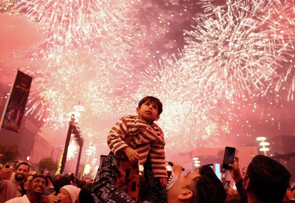 Ребенок наблюдает за фейерверком во время новогодних торжеств в Лусаиле, Катар.