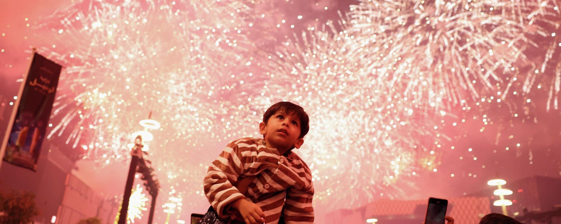 Дзіця назірае за феерверкам падчас навагодніх урачыстасцей у Лусаіле, Катар - Sputnik Беларусь, 1920, 01.01.2026