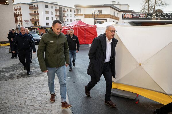 Президент Швейцарии Ги Пармелен и государственный советник и председатель кантона Вале Матиас Рейнар осматривают место пожара.
