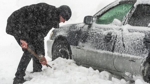 Мужчина откапывает автомобиль от снега - Sputnik Беларусь