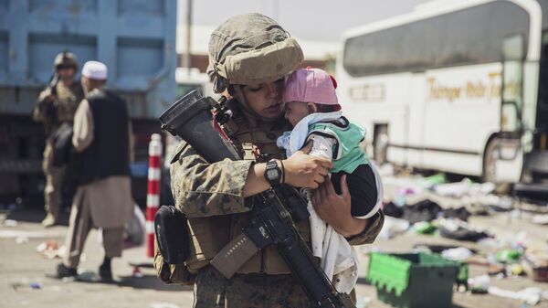 Военнослужащий с ребенком на руках в Афганистане - Sputnik Беларусь