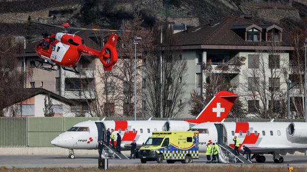 Швейцарский санитарный вертолет приземляется рядом с самолетами швейцарской санитарной авиации в аэропорту Сьон после пожара и взрыва в баре Le Constellation во время новогодней вечеринки на фешенебельном горнолыжном курорте Кранс-Монтана на юго-западе Швейцарии - Sputnik Беларусь