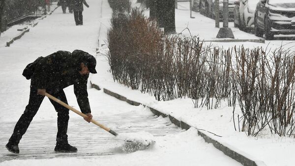 Мужчина убирает снег - Sputnik Беларусь