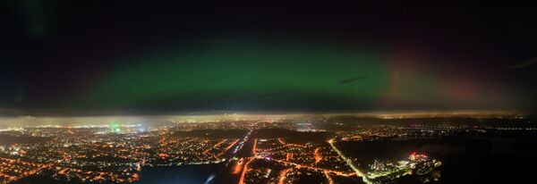 Яркое зеленое и красное северное сияние, видимое невооруженным глазом вечером над Дуйсбургом. Фото: Кристоф Райхвайн/dpa (picture alliance через Getty Images)