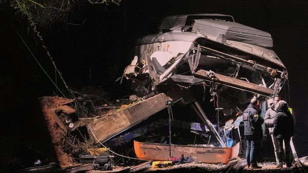 Аварийные службы работают на месте происшествия после схода с рельсов пригородного поезда в результате обрушения подпорной стены на железнодорожные пути в Гелиде, недалеко от Барселоны - Sputnik Беларусь