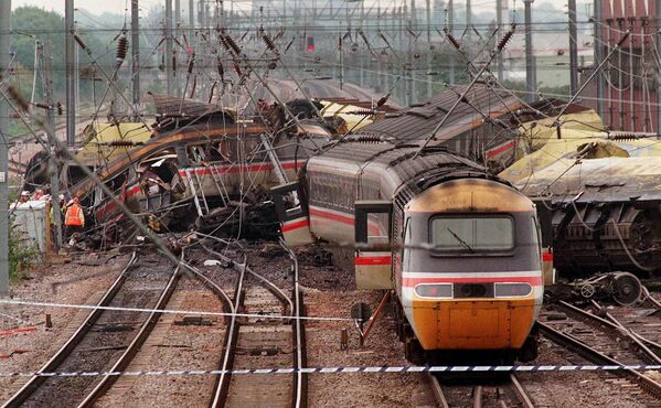 Разрушенные вагоны возле станции Саутхолл на западе Лондона 19 сентября 1997 года после столкновения скоростного пригородного и грузового поездов. В результате инцидента  погибли по меньшей мере семь человек и до 150 получили ранения. (AP Photo/Alistair Grant)