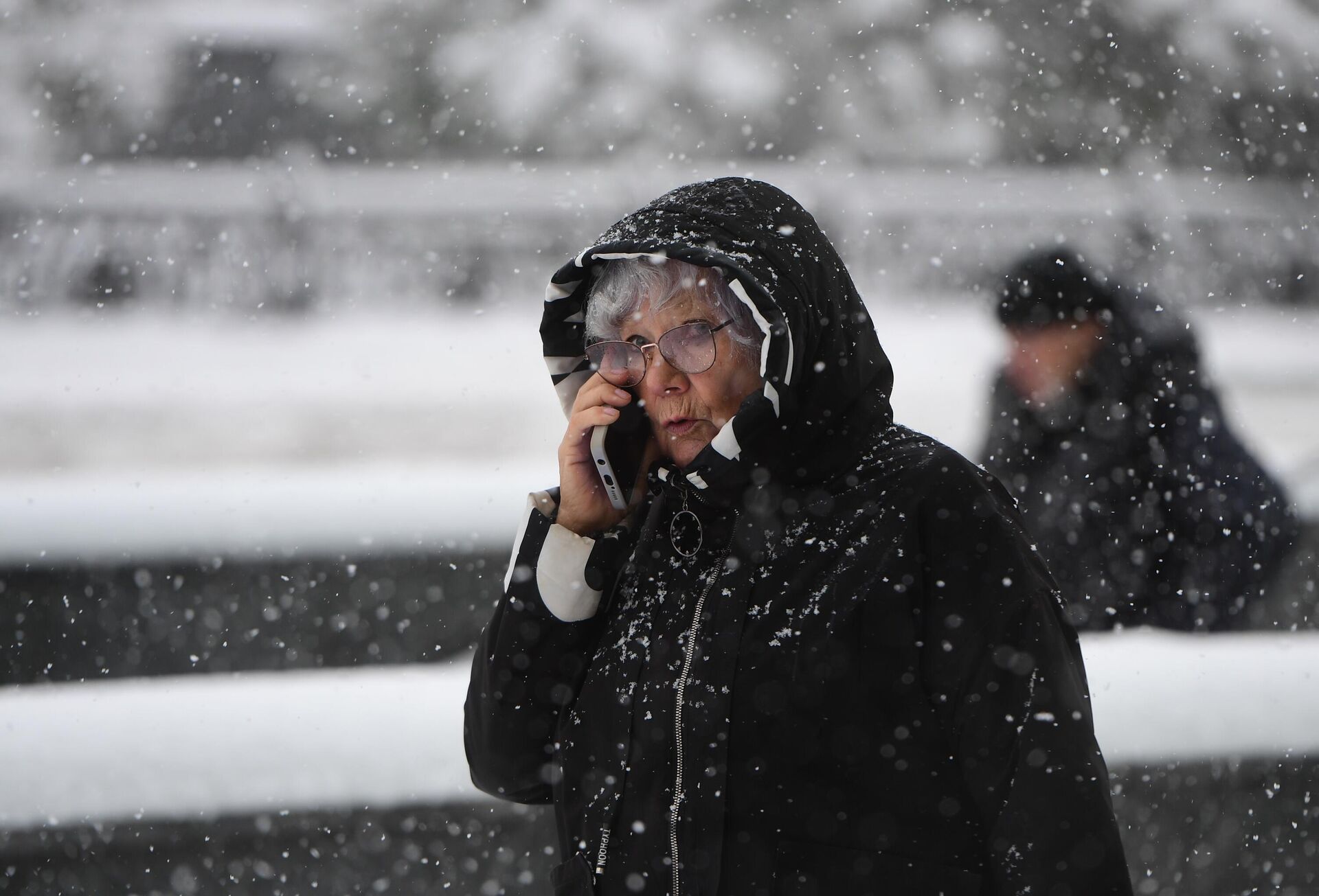 Женщина с телефоном во время снегопада - Sputnik Беларусь, 1920, 27.01.2026