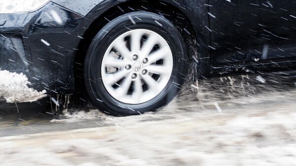 Колесо автомобиля, едущего во время снегопада - Sputnik Беларусь