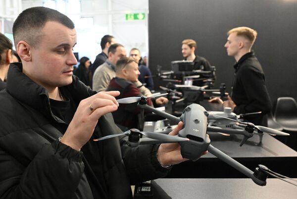 Посетитель держит квадрокоптер DJI. - Sputnik Беларусь