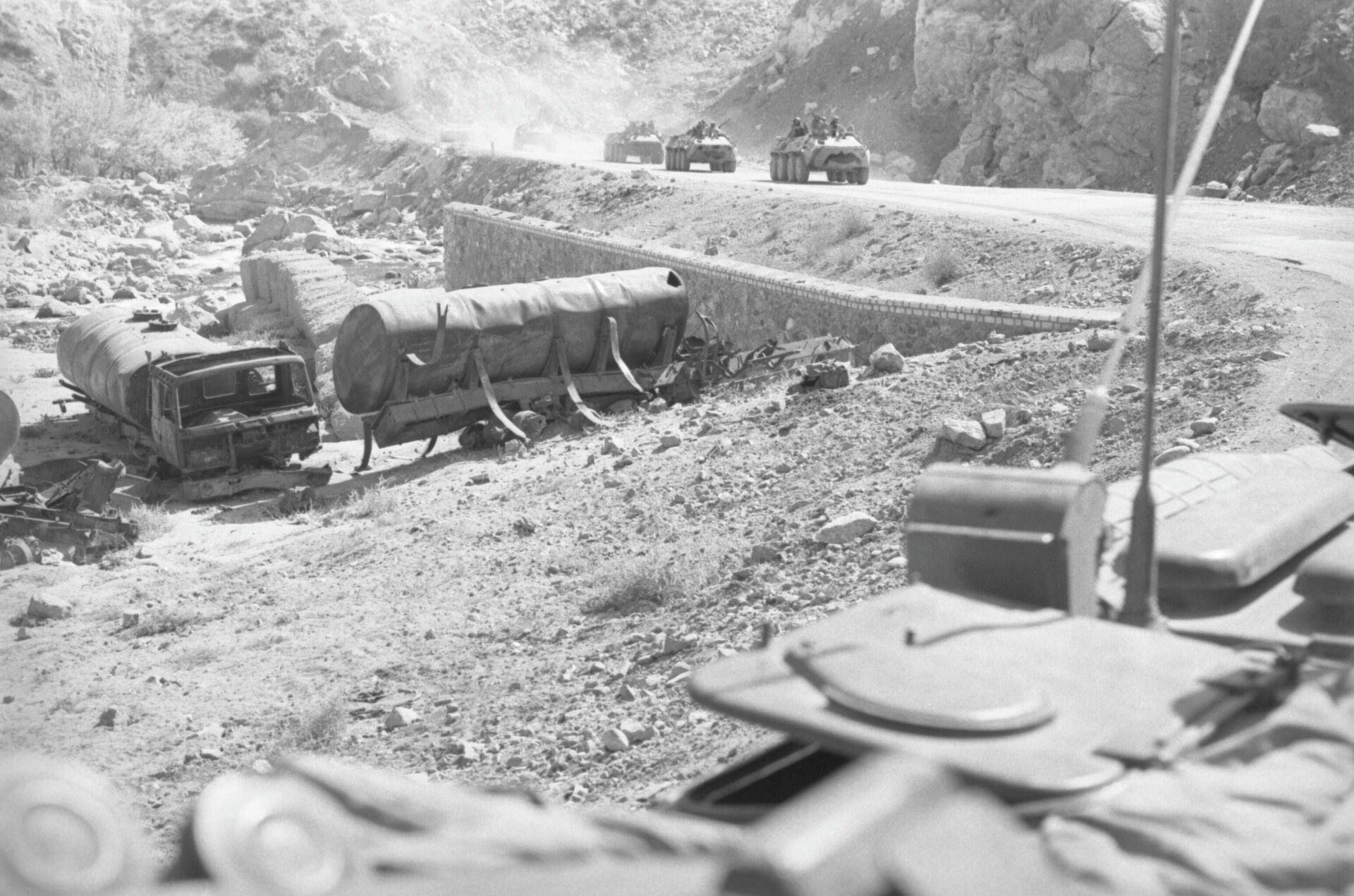 Колонна советских войск едет мимо сгоревших бензовозов