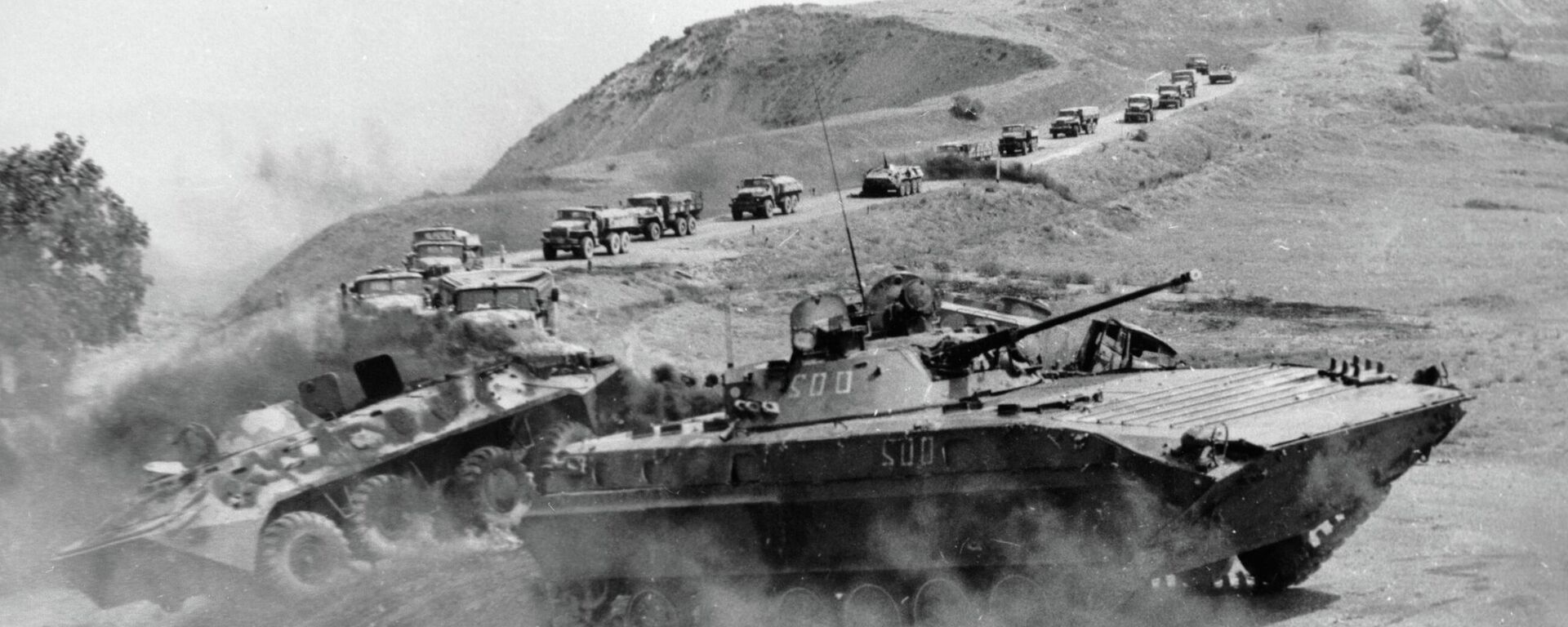 Калона аўтамашын у суправаджэнні баявой машыны пяхоты і бронетранспарцёраў ідзе па дарозе ў Афганістане - Sputnik Беларусь, 1920, 15.02.2026