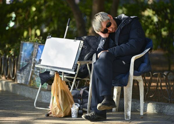 Уличный художник спит на набережной Ялты.