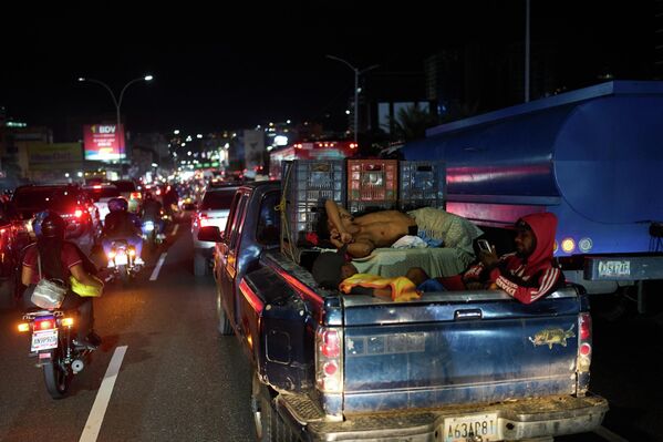 Мужчина спит в кузове пикапа, застрявшего в пробке в Каракасе, Венесуэла.