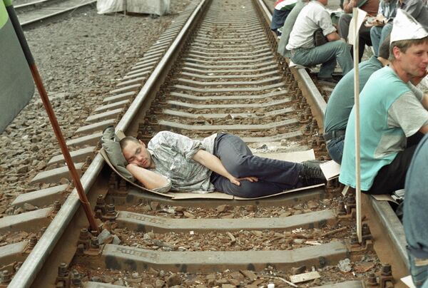 Шахтер заснул на рельсах во время акции протеста на железной дороге из-за задержки заработной платы (фото 1998 года).