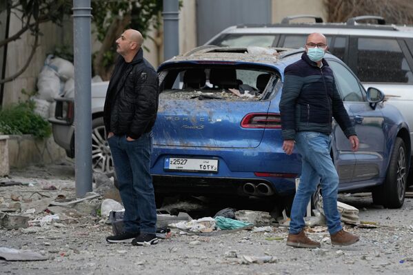 Жители осматривают руины отеля, пострадавшего от израильского авиаудара в Хазмие, к востоку от Бейрута.