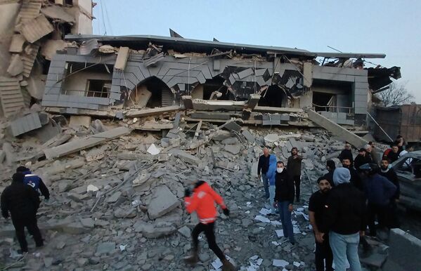 Спасатели собрались перед разрушенным центром ливанской исламской группировки после нанесенного по зданию израильского удара, в южном портовом городе Сидон, Ливан.