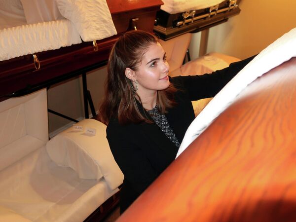 На фото, сделанном в октябре 2018 года, директор похоронного бюро Дариен Фредерик поправляет экспозицию гробов в своем похоронном бюро в Уотертауне, штат Нью-Йорк.В сравнении с предыдущими поколениями, когда сферу похоронных услуг выбирали в основном мужчины, сейчас ситуация изменилась с точностью до наоборот.  