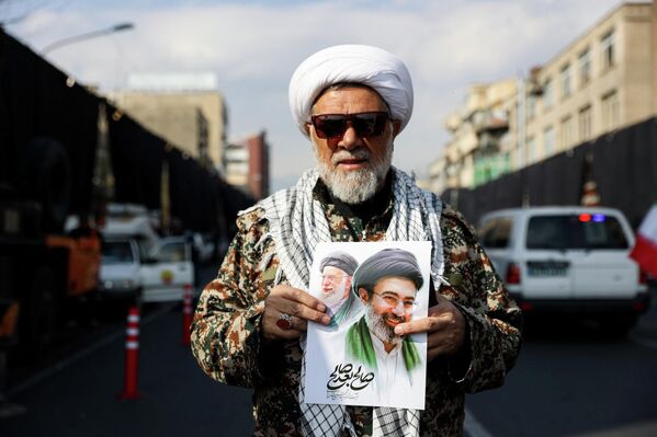 Мужчина держит плакат с изображением нового верховного лидера Ирана Моджтабы Хаменеи и покойного верховного лидера Ирана аятоллы Али Хаменеи, Иран - Sputnik Беларусь