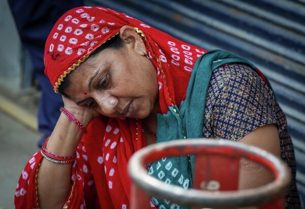 В индийском Нойде местная жительница с пустым газовым баллоном сидит возле газового агентства на фоне перебоев в поставках, возникших после начала американо-израильского конфликта с Ираном (12 марта 2026 года).