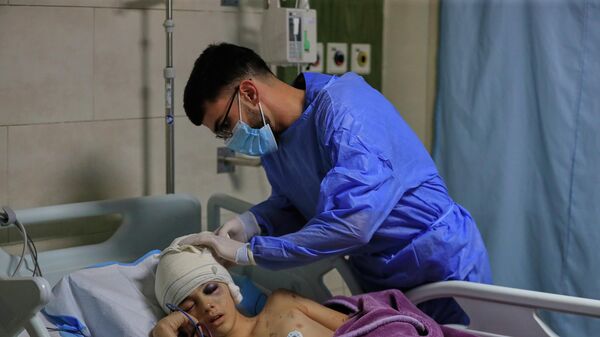 Ливанский медик оказывает помощь раненому мальчику - Sputnik Беларусь