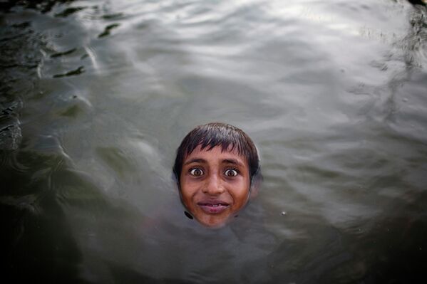 Ребенок плавает в реке Буриганга возле завода по переработке алюминия на окраине Дакки, Бангладеш - Sputnik Беларусь