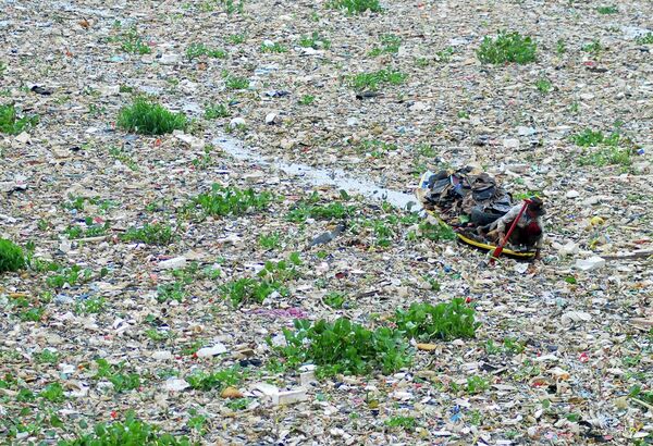 Сборщик мусора на лодке собирает пригодные для переработки предметы из замусоренной реки Читарум, Западная Ява, Индонезия - Sputnik Беларусь