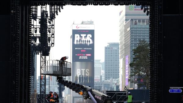 Рабочие готовятся к концерту-возвращению K-pop группы BTS на площади Кванхвамун в Сеуле - Sputnik Беларусь