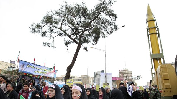 Жители Ирана рядом с баллистической ракетой класса земля-земля большой дальности Emad в Тегеране - Sputnik Беларусь