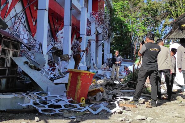 Полицейский осматривает поврежденное землетрясением здание в индонезийской провинции Северный Сулавеси. - Sputnik Беларусь