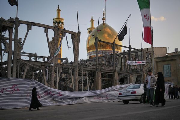 Прохожие идут возле разрушенного комплекса Гранд-Хоссейния, пострадавшего от американо-израильских авиаударов в Зенджане. Этот город является одним из культурных центров Ирана и считается родиной персидских ковров. - Sputnik Беларусь