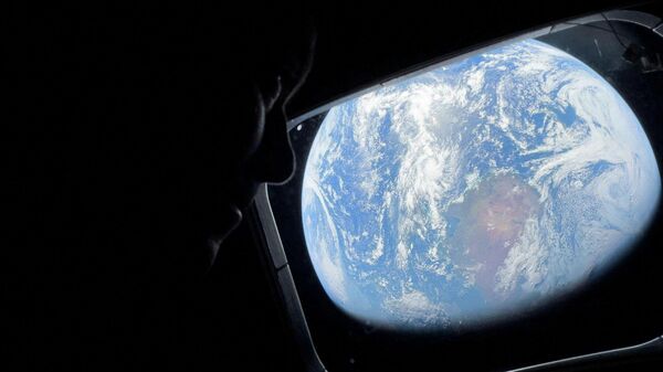 Астронавт НАСА и командир миссии Артемида-2 Рид Уайзман смотрит из иллюминатора космического корабля Орион на Землю - Sputnik Беларусь