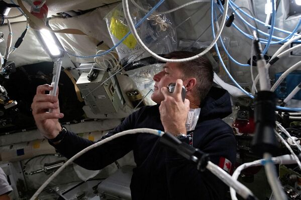 Канадский астронавт Джереми Хансен бреется на пятый день миссии. - Sputnik Беларусь