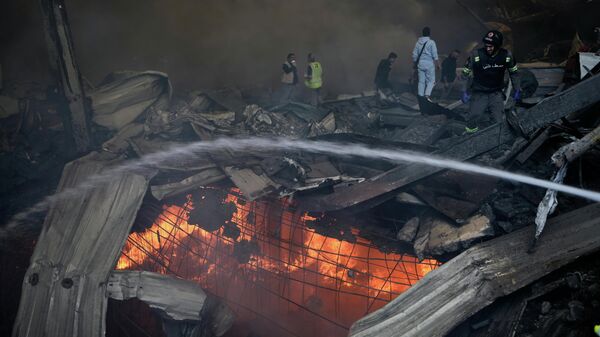 Пожарные пытаются потушить пламя на месте израильского авиаудара по многоквартирному дому в Бейруте, Ливан - Sputnik Беларусь