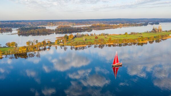 Экспедыцыйная яхта "Петр Первый" побач з востравам Кіжы. На другім плане – Праабражэнская царква XVIII стагоддзя, царква Покрыва Прасвятой Багародзіцы і званіца, якія ўваходзяць у склад архітэктурнага ансамбля Дзяржаўнага гісторыка-архітэктурнага музея-запаведніка "Кіжы" ў Карэліі. - Sputnik Беларусь