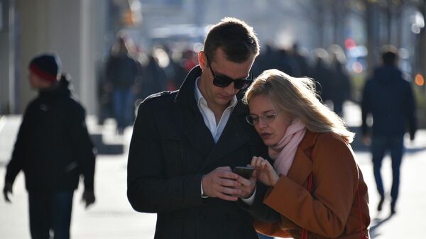 Прохожие на улице смотрят в смартфон - Sputnik Беларусь