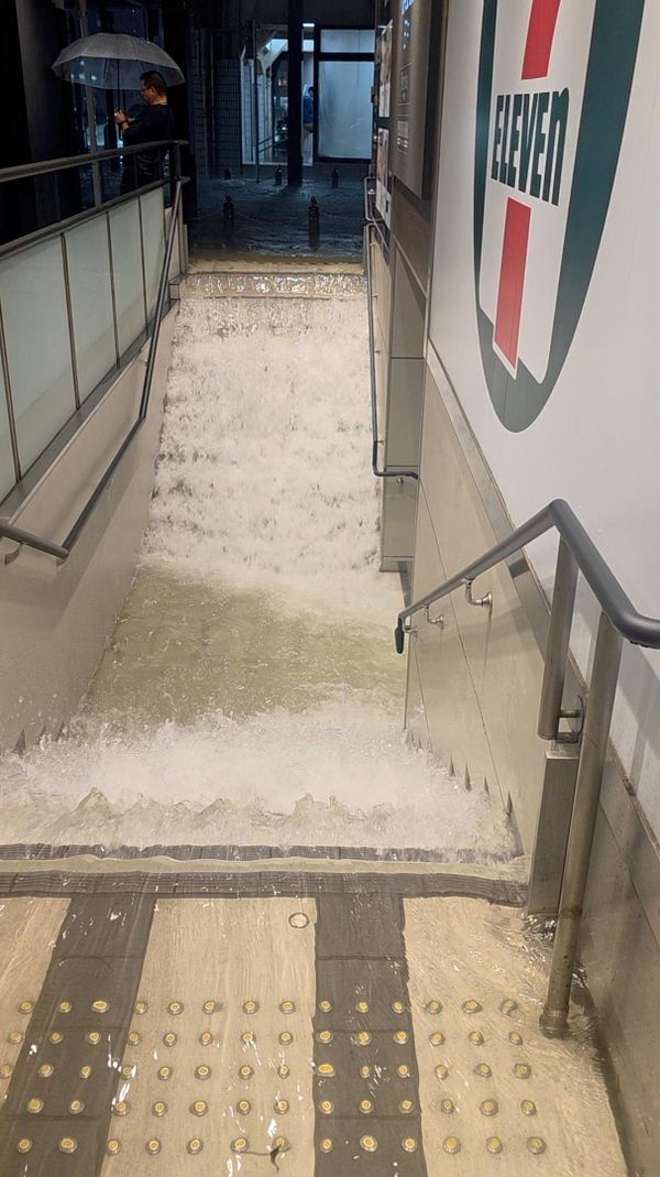 Вода течет по лестнице торгового центра Perie Chiba Mall после сильного дождя в городе Тиба.