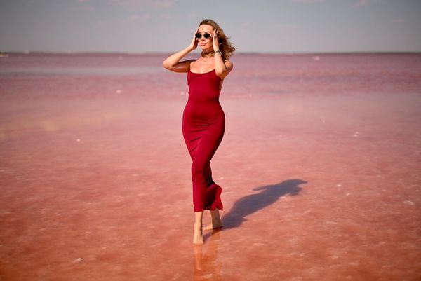 Женщина на озере Сасык-Сиваш. В закатные часы вода там становится розовой. Сасык-Сиваш – горько-соленый водоем, известный своими целебными грязями и соляными берегами. Ветер поднимает над водой соленую пыль, и воздух здесь пахнет морем вперемешку со степными травами.