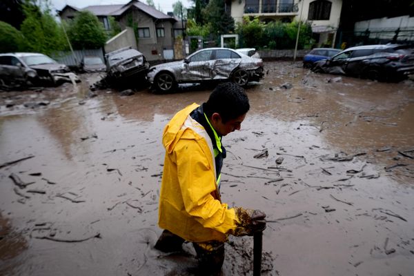 Мужчина пробирается по улице, затопленной мутной водой в Сантьяго. - Sputnik Беларусь