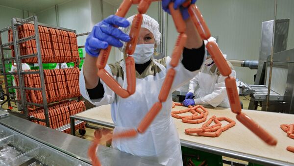 Рабочий упаковывает продукцию на фабрике мясной гастрономии, архивное фото - Sputnik Беларусь