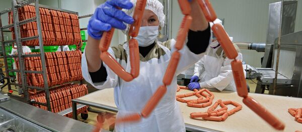 Рабочий упаковывает продукцию на фабрике мясной гастрономии, архивное фото - Sputnik Беларусь