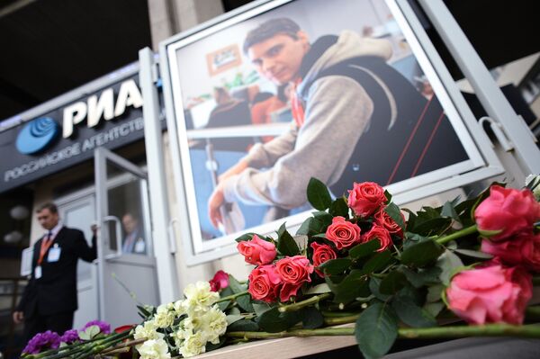 Цветы в память о погибшем на Украине фотокорреспонденте Андрее Стенине у здания агентства МИА Россия сегодня - Sputnik Беларусь