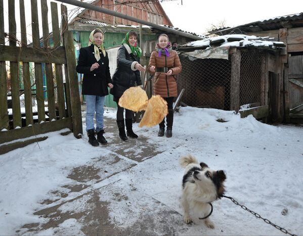 Девушки из деревни Погост Гомельской области бросают собаке блины - Sputnik Беларусь