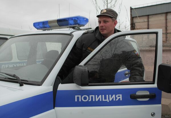 Сотрудник полиции садится в машину - Sputnik Беларусь