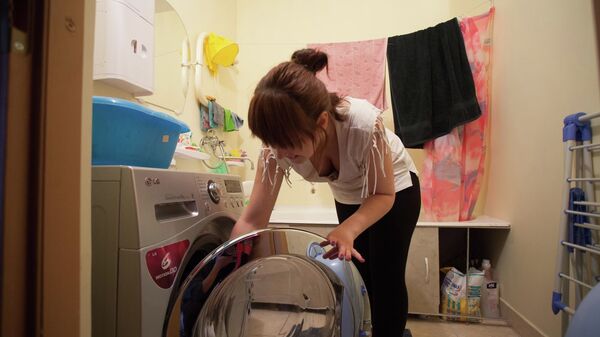 Домохозяйка загружает стиральную машину - Sputnik Беларусь
