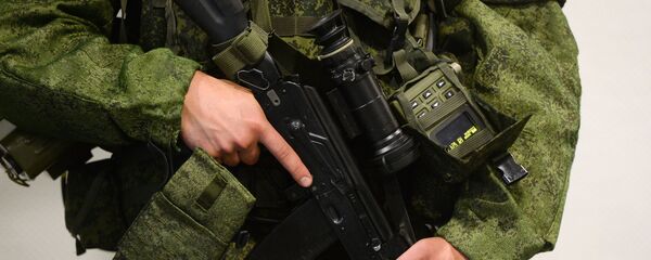 Мужчина демонстрирует новую экипировку российского военнослужащего - Sputnik Беларусь