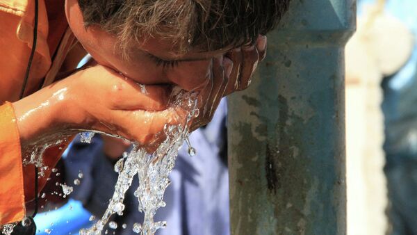Ребенок пьет воду из колонки в Пакистане - Sputnik Беларусь