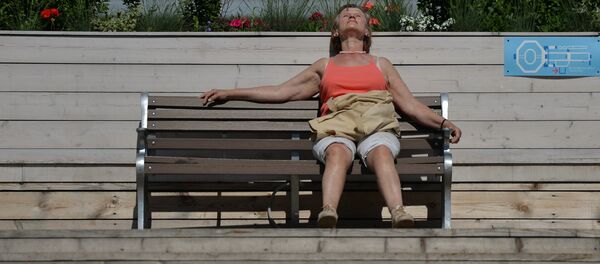 Женщина загорает на скамейке - Sputnik Беларусь