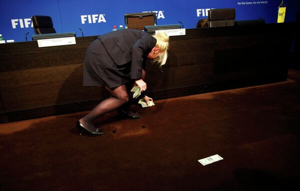 Сотрудница собирает с пола доллары на проведение ЧМ-2026 в КНДР, брошенные в президента ФИФА на пресс-конференции Сотрудница собирает с пола доллары на проведение ЧМ-2026 в КНДР, брошенные в президента ФИФА на пресс-конференции - Sputnik Беларусь