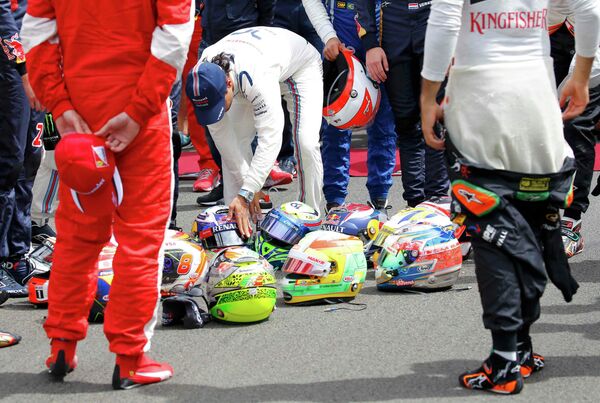 Гонщики перед стартом Гран-при Венгрии сложили шлемы на асфальт, почтив память погибшего пилота Жюля Бьянки  - Sputnik Беларусь